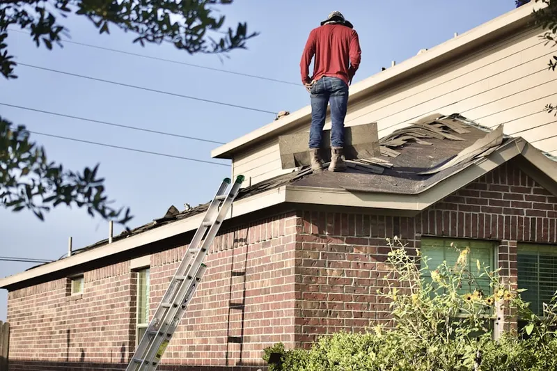 Professional roofer working on a residential roof in Winton
